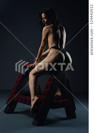 Woman Posing on Padded A-Frame bench prepared for bdsm game 124442612