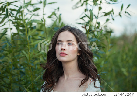 Stylish spring woman walking outdoors on nature background, fashion beauty portrait Stylish spring woman walking outdoors on nature background, fashion beauty portrait 124443247