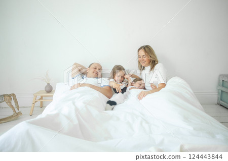 Relaxing family on the bed together at home 124443844