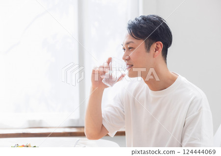 A man drinking a glass of water A man drinking a glass of water 124444069