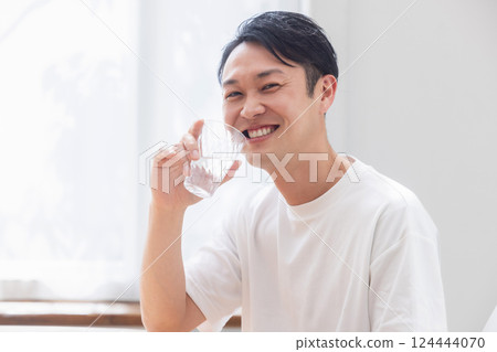 A man drinking a glass of water A man drinking a glass of water 124444070