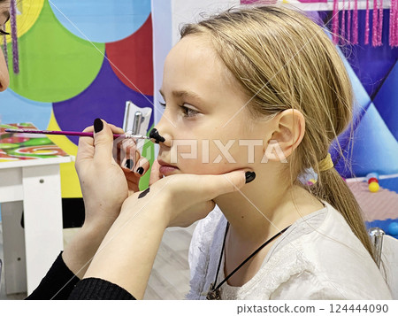 Brunette child girl waiting while getting creative art makeup Brunette child girl waiting while getting creative art makeup 124444090