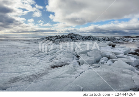 A vast, icy landscape under a cloudy sky 124444264
