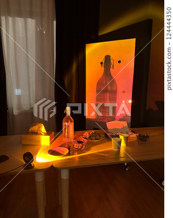 Sunlight casts glowing shadows across afternoon snacks. Warmth, stillness, and the quiet poetry of light and object interaction in interior space 124444350