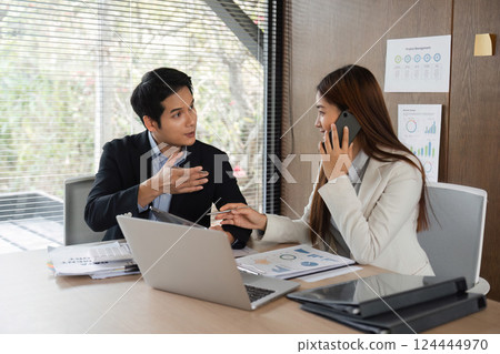 Client Consultation and Professional Interaction. A man explaining business ideas to a woman on a phone call during a collaborative meeting. Client Consultation and Professional Interaction. A man explaining business ideas to a woman on a phone call during a collaborative meeting. 124444970