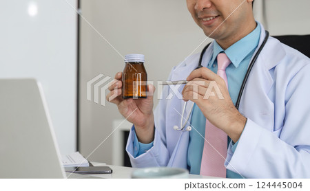 Medication Management and Patient Education. A healthcare provider explains medication using a bottle during a virtual consultation. 124445004