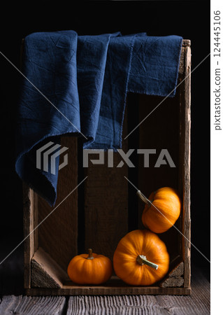 Three orange Baby Boo pumpkins squash in wooden box 124445106