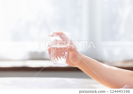 Hand holding a glass of water 124445198