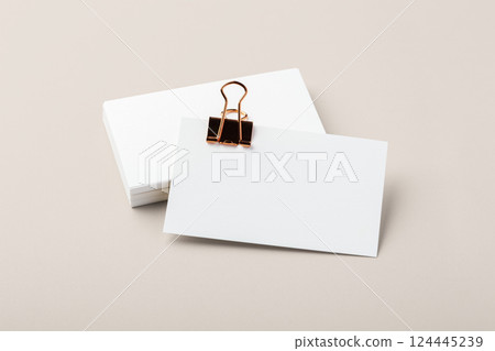 Blank business card with gold binder clip mockup on beige background Blank business card with gold binder clip mockup on beige background 124445239