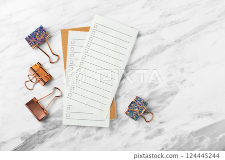 Check list paper with rose gold binder clip on marble table background, top view 124445244