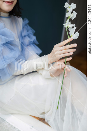 Woman with flowers by the window Woman with flowers by the window 124445421