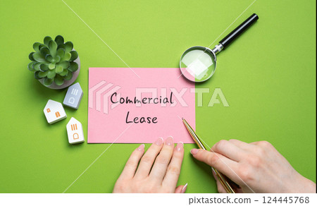 Commercial lease concept. Legally binding contract between a landlord and a business tenant, allowing the tenant to use a property for commercial purposes in exchange for rent. Woman points to notes 124445768