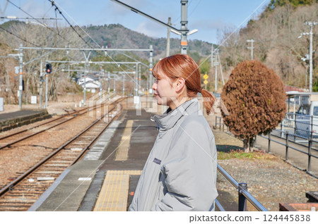 A woman waiting for a train on the station platform in the countryside 124445838