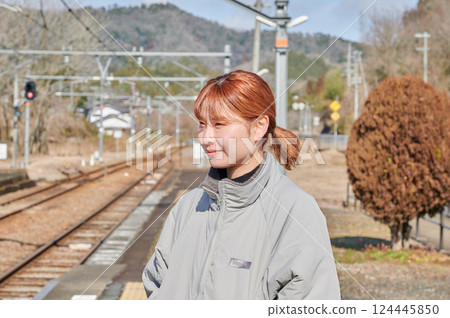 A woman waiting for a train on the station platform in the countryside 124445850