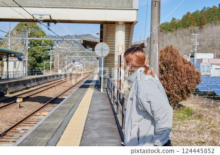 一名婦女在鄉間車站台上等火車 一名婦女在鄉間車站台上等火車 124445852