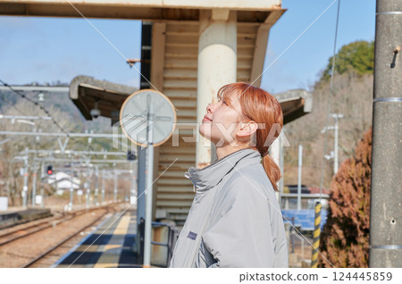 A woman waiting for a train on the station platform in the countryside 124445859