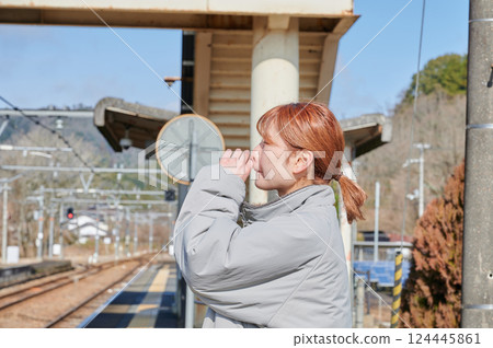 A woman waiting for a train on the station platform in the countryside 124445861