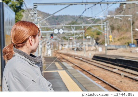 一名婦女在鄉間車站台上等火車 一名婦女在鄉間車站台上等火車 124445892