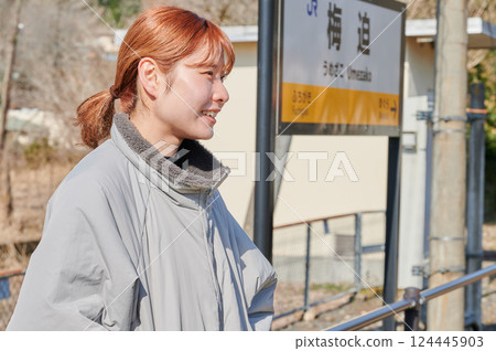 A woman waiting for a train on the station platform in the countryside 124445903