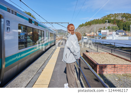 A woman waiting for a train on the station platform in the countryside 124446217