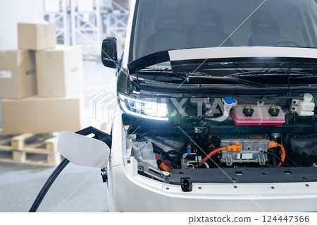 Charging electric van with open hood Charging electric van with open hood 124447366