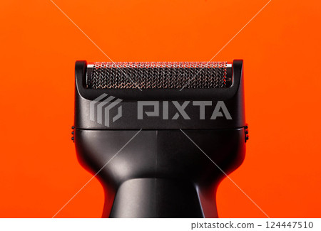 Modern shaving head on a red background. Beard care, close-up Modern shaving head on a red background. Beard care, close-up 124447510