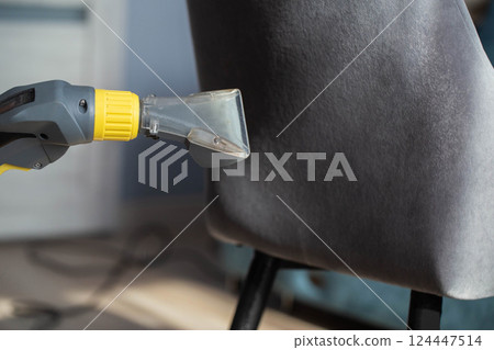 Dry cleaning services, washing and cleaning gray fabric chairs with a washing vacuum cleaner, industry. Copy space for text Dry cleaning services, washing and cleaning gray fabric chairs with a washing vacuum cleaner, industry. Copy space for text 124447514