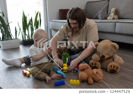 mom plays with toys with a small child mom plays with toys with a small child 124447529