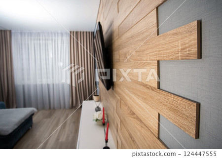 Modern interior in the living room with wooden laminate flooring, wall-hung cabinets, LCD TV and air conditioning. Stylish renovation in the apartment. Copy space for text Modern interior in the living room with wooden laminate flooring, wall-hung cabinets, LCD TV and air conditioning. Stylish renovation in the apartment. Copy space for text 124447555