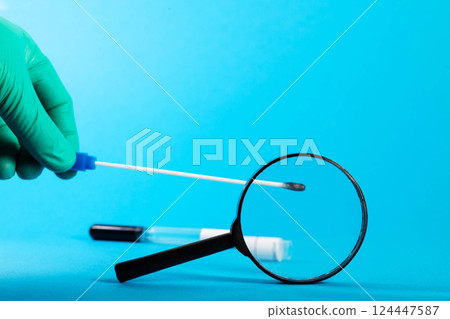 The doctor's hand holds a scraping from the throat and pharynx of the oropharynx for the presence of bacteria and infections, sensitivity to antibiotics. Copy space for text The doctor's hand holds a scraping from the throat and pharynx of the oropharynx for the presence of bacteria and infections, sensitivity to antibiotics. Copy space for text 124447587