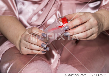 A container with a stool test is in the girl s hands. Concept for studying stool analysis in gastroenterology, coprogram, close-up 124447596