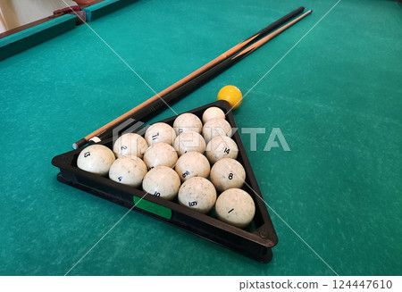 Balls with a cue lie on the green cloth of a billiard table, background. Copy space for text 124447610