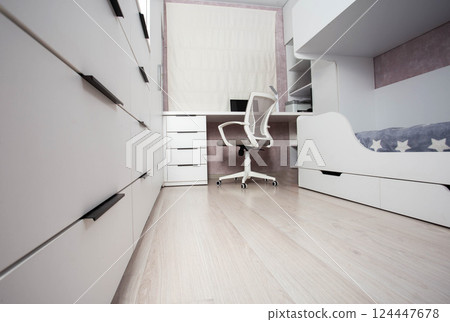 Interior of a modern children's bedroom with a bunk bed, a chest of drawers and a table with a laptop and a computer chair. White bedroom interior, blinds, furniture to order Interior of a modern children's bedroom with a bunk bed, a chest of drawers and a table with a laptop and a computer chair. White bedroom interior, blinds, furniture to order 124447678