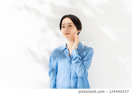 女人撫摸著臉頰，陽光透過樹叢，美麗 124448357