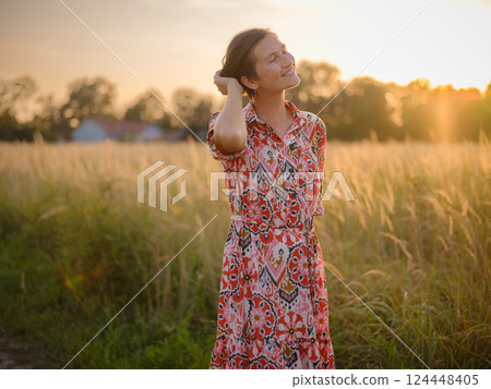 boho chic woman in a floral dress in European countryside boho chic woman in a floral dress in European countryside 124448405