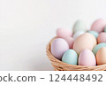 Pastel Easter eggs in baskets on light background 124448492