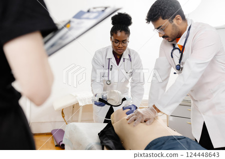 Doctors practicing cardiopulmonary resuscitation on a medical manikin 124448643