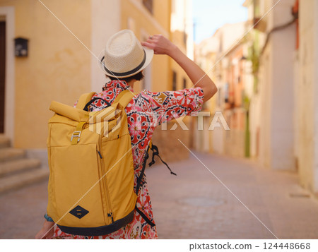Woman strolls through colorful streets of Spanish coastal town 124448668