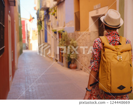 Woman strolls through colorful streets of Spanish coastal town 124448669