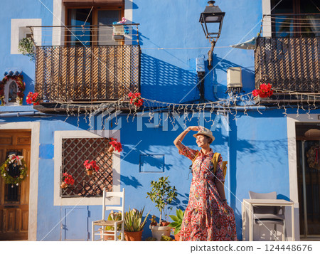 Woman strolls through colorful streets of Spanish coastal town 124448676