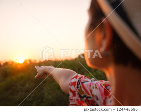 Warm sunset hues create peaceful, dreamy countryside atmosphere. 124448686