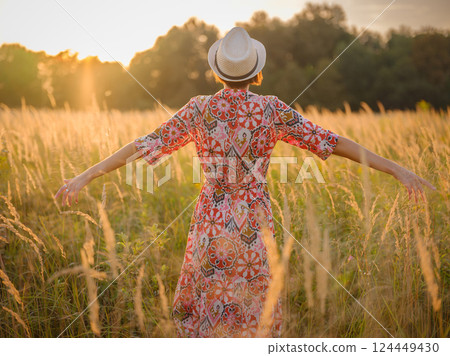boho chic woman in a floral dress in European countryside 124449430