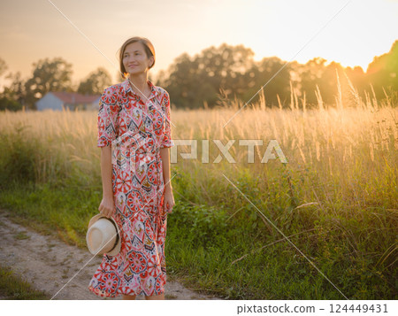 boho chic woman in a floral dress in European countryside 124449431