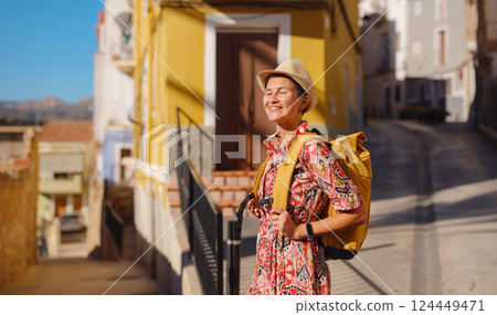 Woman strolls through colorful streets of Spanish coastal town 124449471