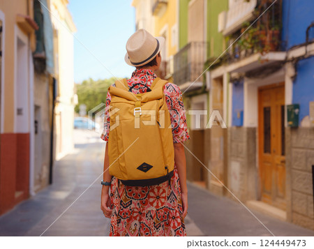 Woman strolls through colorful streets of Spanish coastal town 124449473