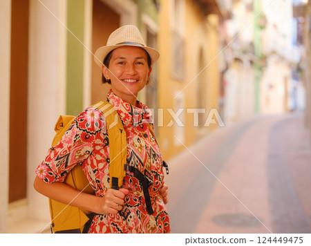 Woman strolls through colorful streets of Spanish coastal town 124449475