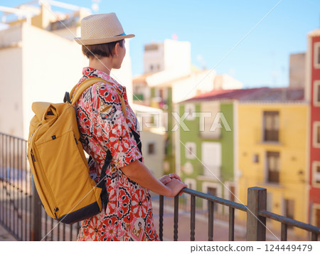 Woman strolls through colorful streets of Spanish coastal town 124449479