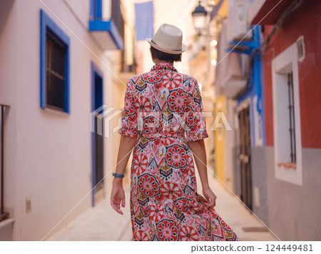 Woman strolls through colorful streets of Spanish coastal town 124449481