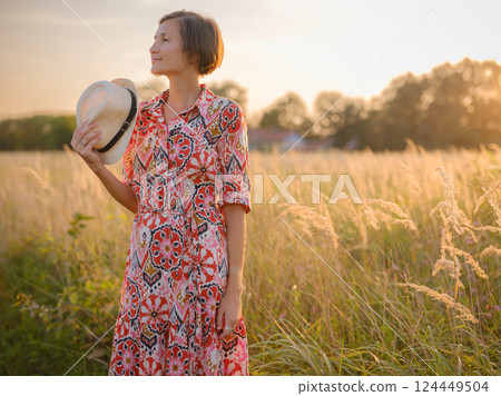 boho chic woman in a floral dress in European countryside boho chic woman in a floral dress in European countryside 124449504