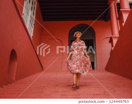 woman in dress and hat exploring vibrant streets of Malacca, Malaysia. 124449763